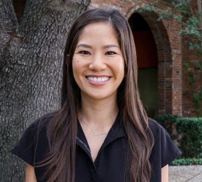 Dr. Nguyen, dentist at McKinney dental practice, smiling outdoors.